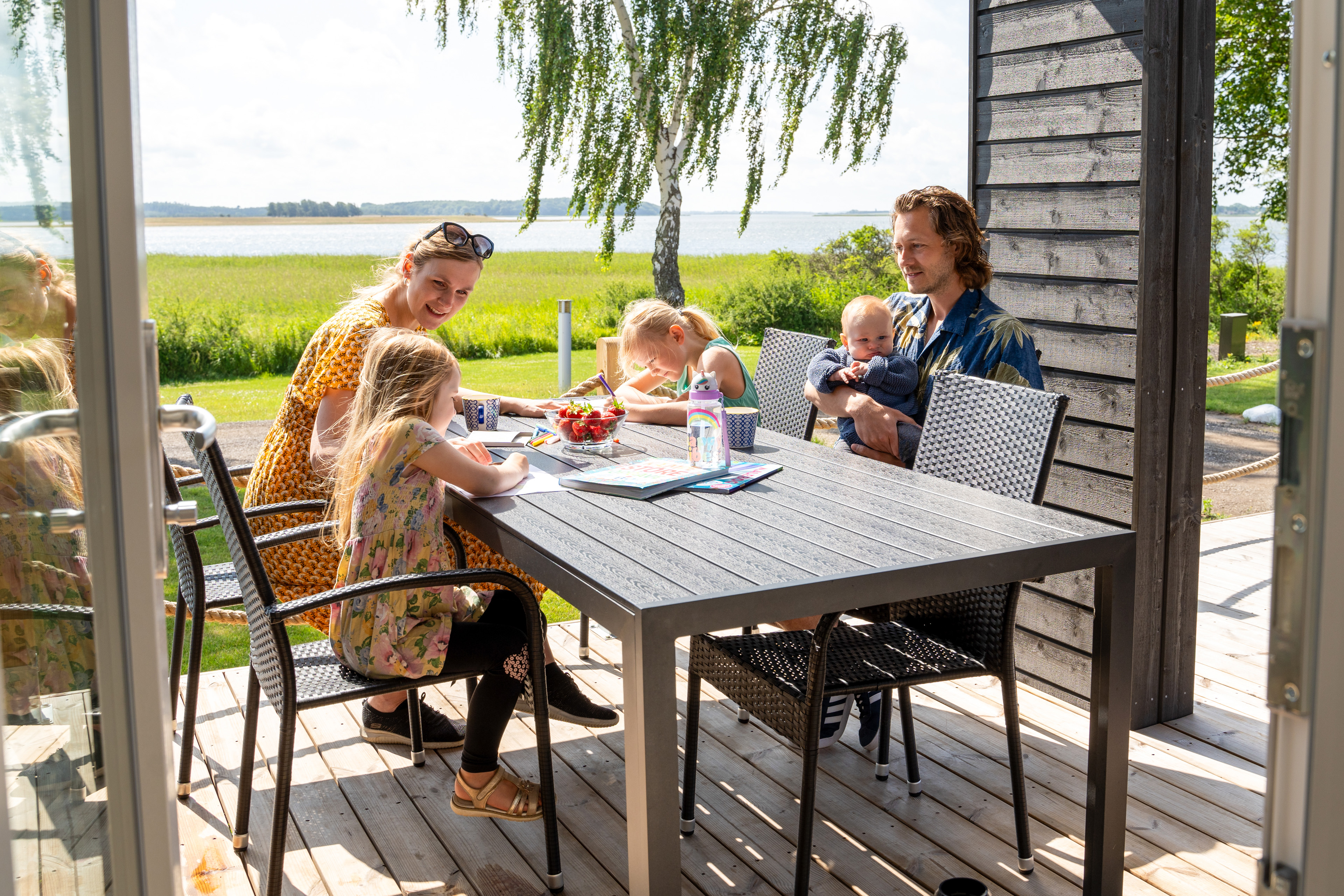 Familie Sidder Ved Bord I Fjordhytte På De Hvide Svaner 5